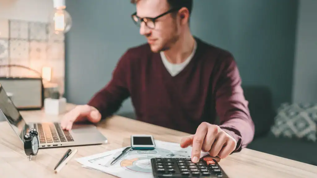 Tax worker desk calculator in Wayne County, Pennsylvania, assisting with tax resolution services at All County Tax Resolution for accurate calculations and solutions