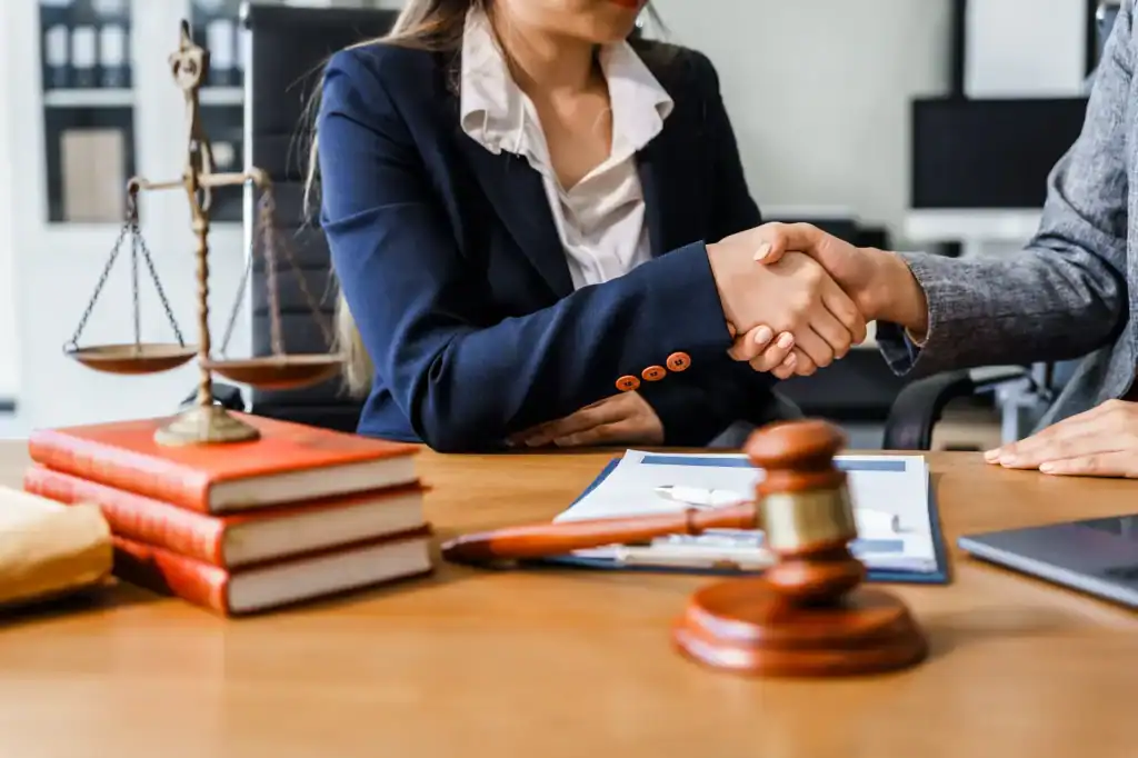 Two professionals shaking hands over a signed legal agreement on a desk in Wayne County, Pennsylvania, representing All County Tax Resolution services