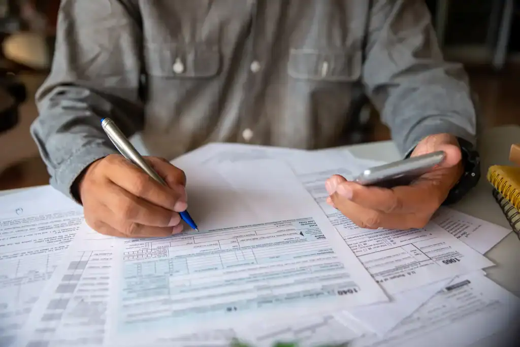 Phone, pen, and tax forms on a desk in Wayne County, Pennsylvania, representing All County Tax Resolution services.